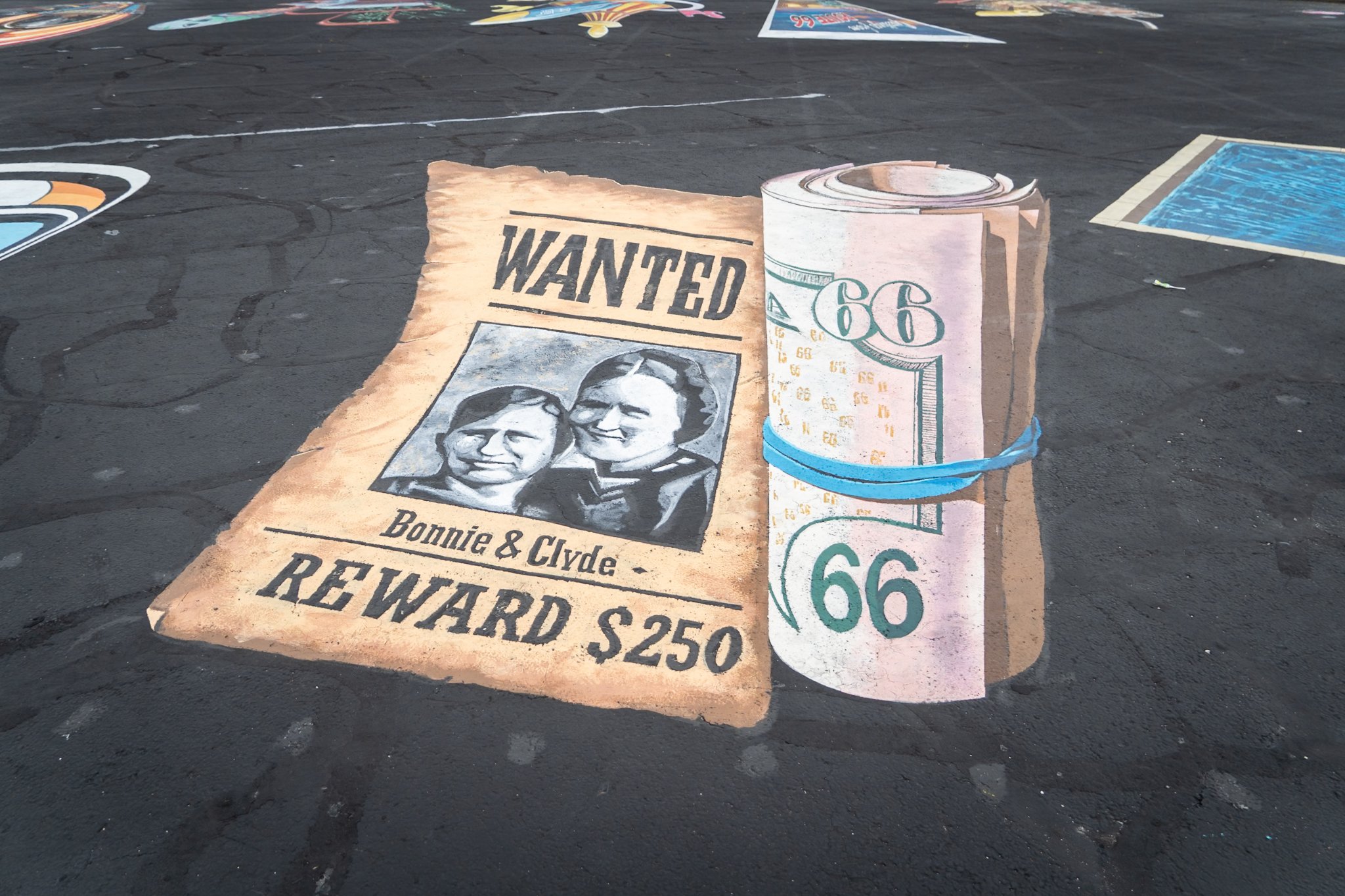 Route 66 3D street art Bonnie and Clyde wanted poster painting near W 7th St and S McCoy Ave